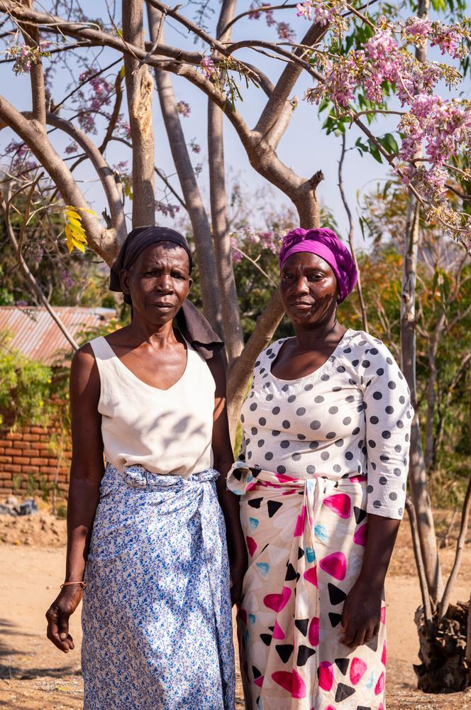 Aida Mailosi et sa fille, Rose Naisoni, devant leur maison à Lirangwe, dans le district de Blantyre. Rose s'occupe de sa mère depuis huit ans ; elle ramasse du sable de la rivière Lirangwe pour le vendre. Juillet 2026 © Jérémy Lempin