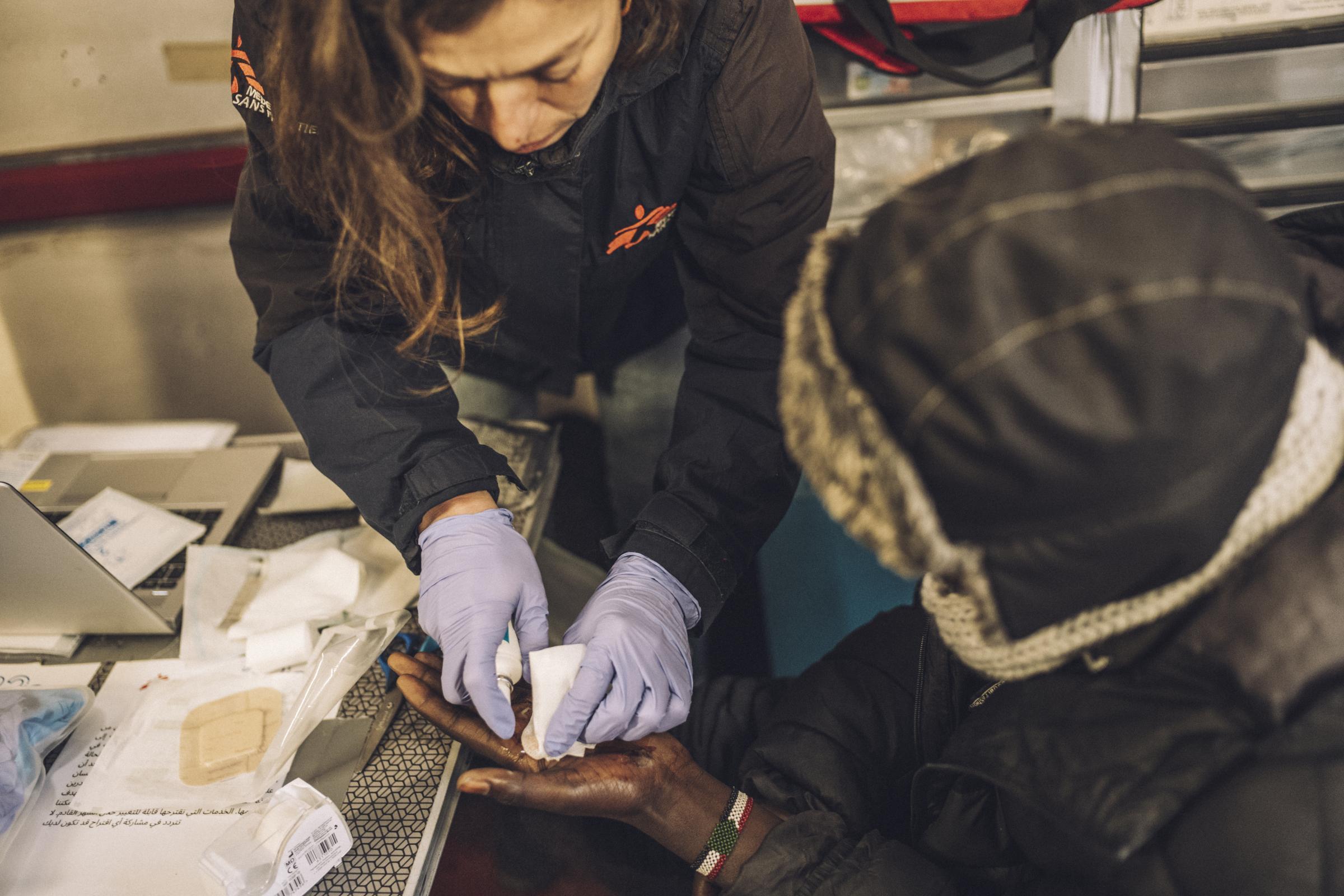 Une infirmière MSF prodigue des soins à la main d’un migrant d’origine soudanaise. Les traumatismes physiques et les petites excoriations sont très fréquents parmi les personnes exilées qui survivent dans des campements insalubres à Calais