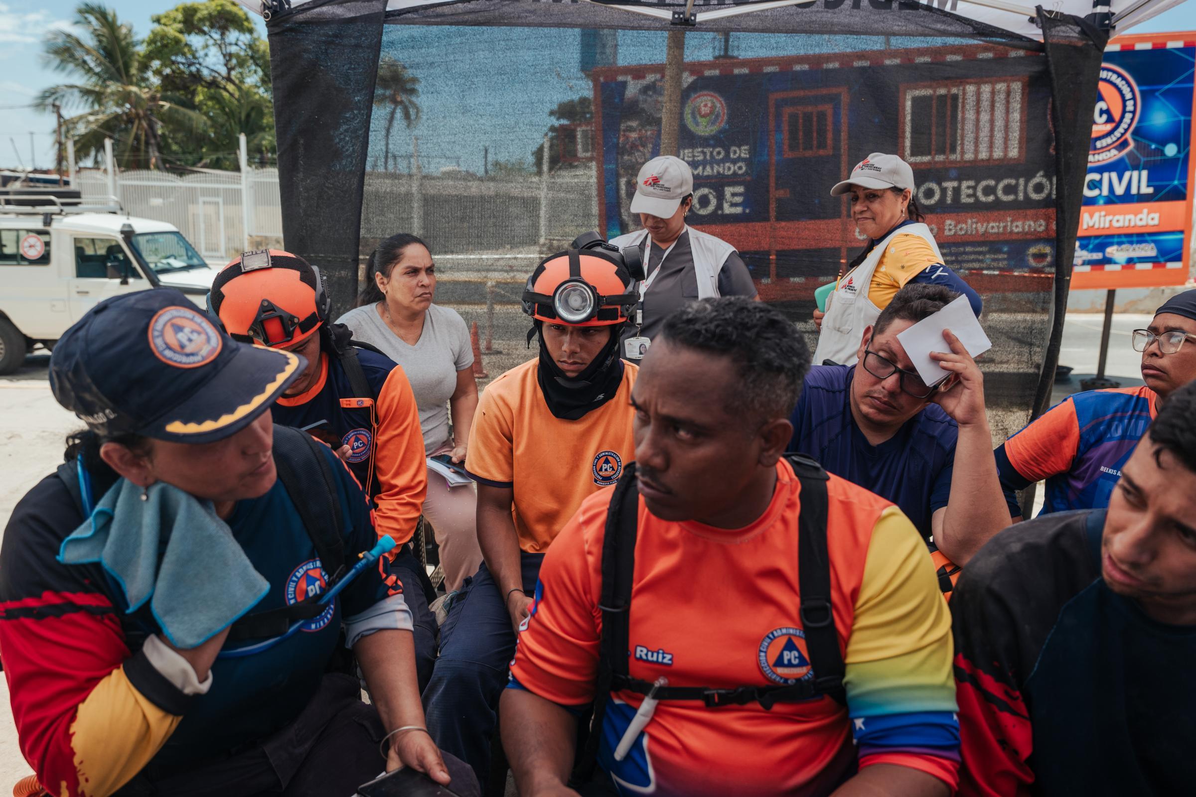Des membres de la Protection civile vénézuélienne font la queue pour recevoir des soins médicaux dans une clinique mobile de Médecins Sans Frontières (MSF) à Playa Grande, installée à proximité du complexe d'habitations qui s'est effondré lors du double séisme, Venezuela