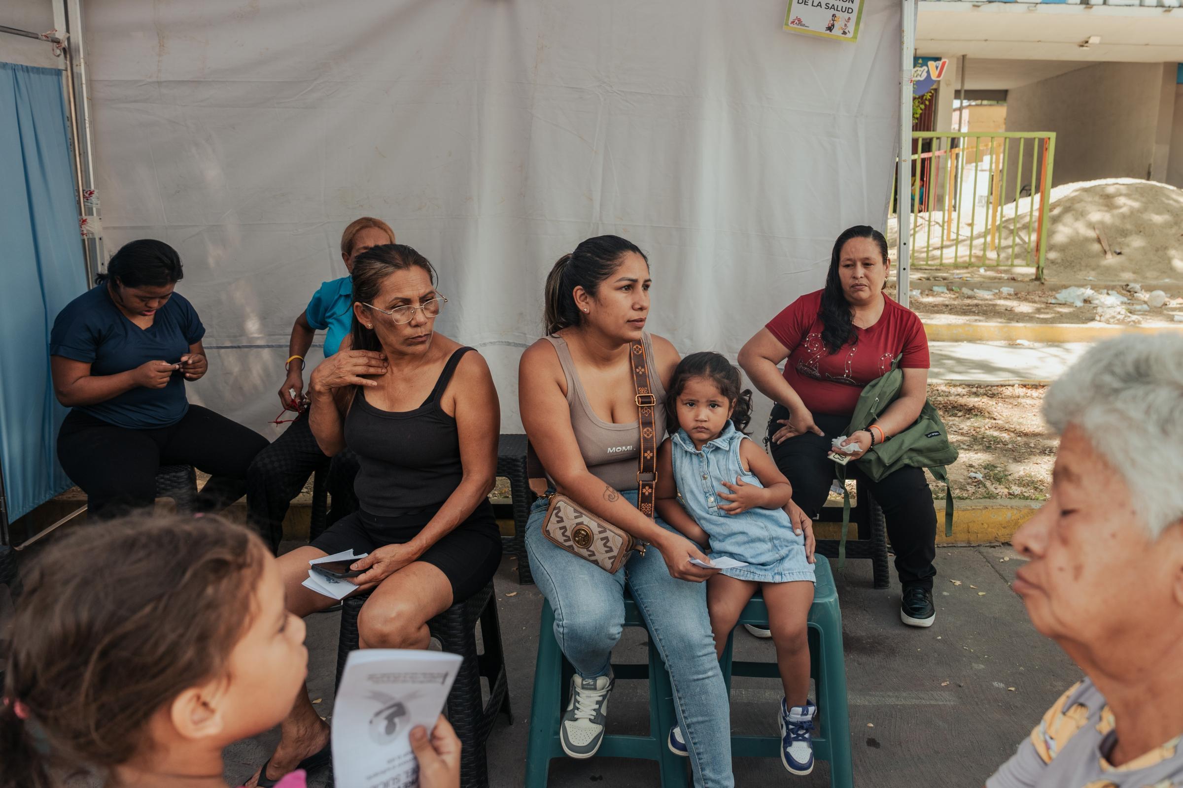 Jhennifer Cardenas, 33 ans, tient sa fille Victoria Serrano, 2 ans, dans ses bras lors d'une consultation médicale sous une tente de Médecins Sans Frontières (MSF) sur l'avenue Bolívar, Venezuela