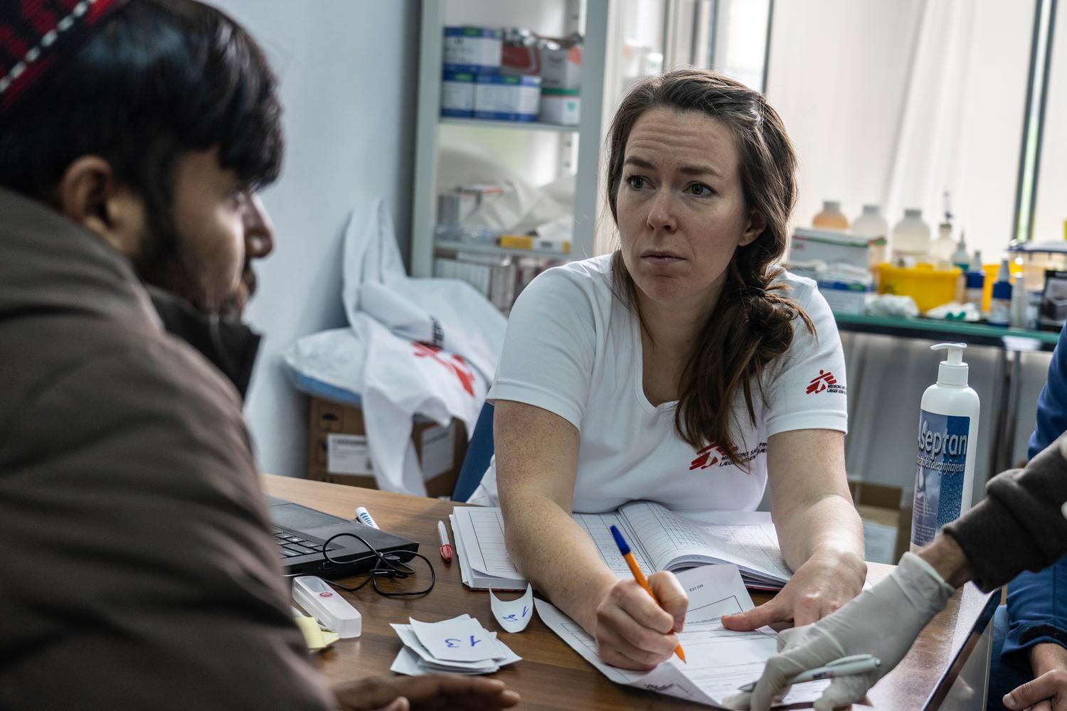 Une médecin MSF ausculte un homme originaire d'Afghanistan souffrant d'une infection cutanée dans une clinique proche du camp de Vučjak. Bosnie. Novembre 2019.